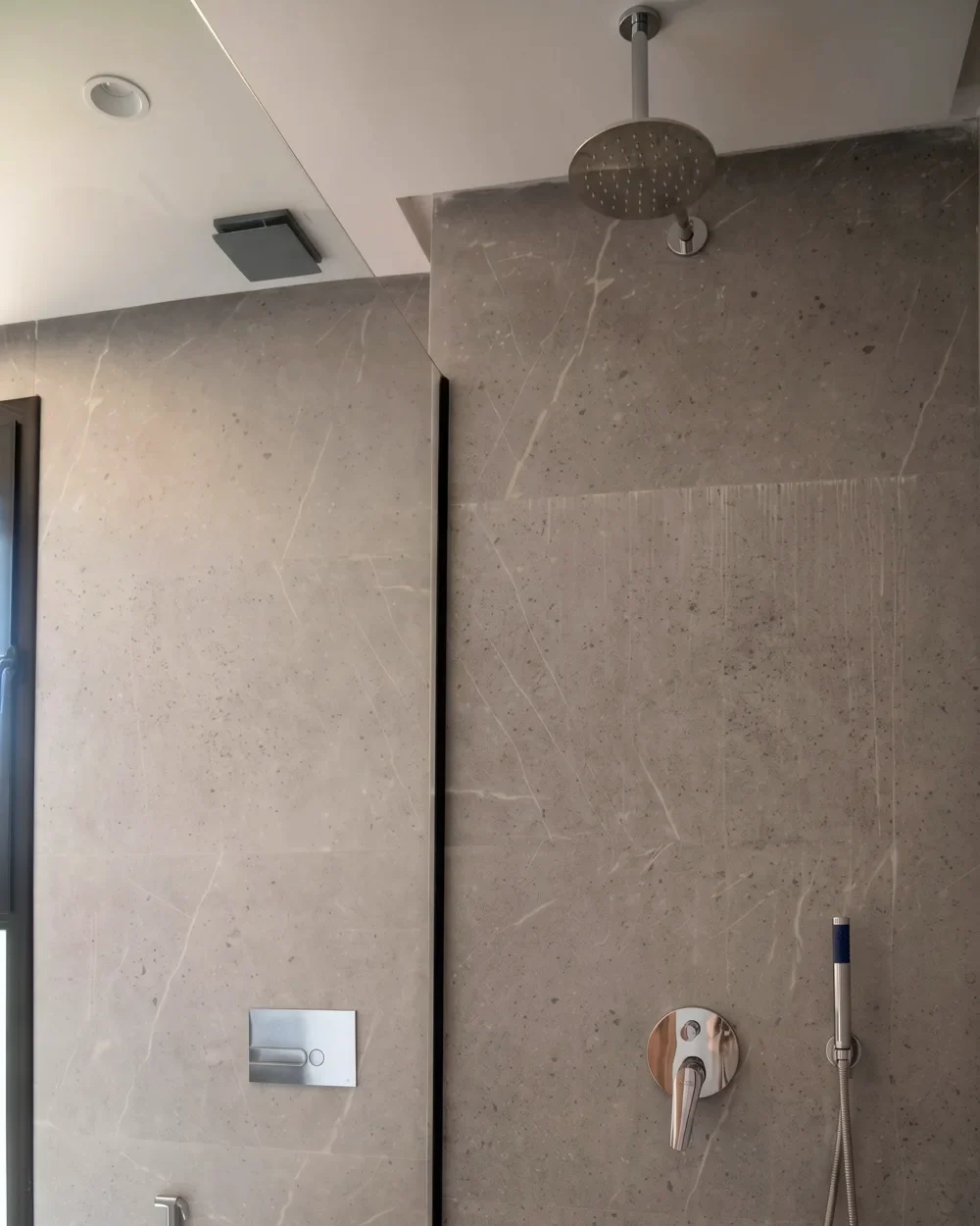 Douche à l’italienne en marbre gris, pomme de pluie et robinetterie — salle de bains de la villa témoin Jnane Oum El Ghite