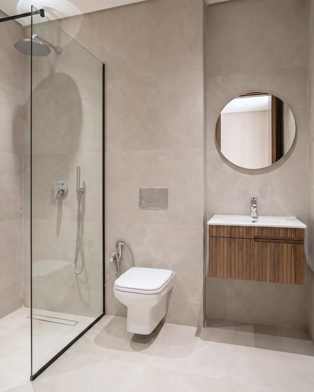 La salle de bains de la villa témoin — douche à l’italienne, microciment et robinetterie noire, photographiée sur place